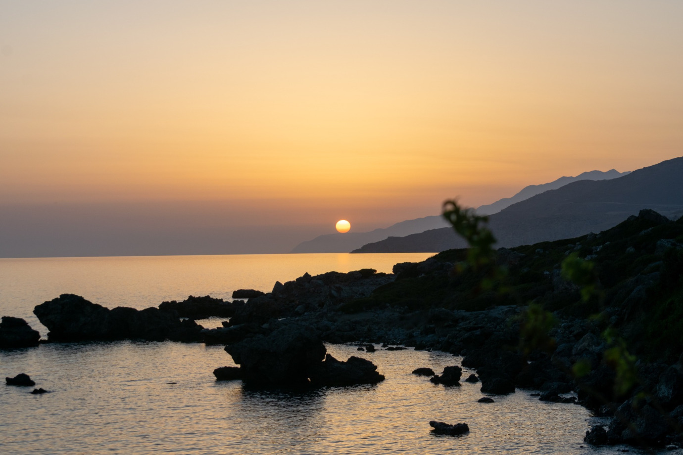 Ηλιοβασίλεμα στο νότιο Ρέθυμνο με τον ήλιο να δύει πάνω από τη θάλασσα και τον ουρανό να έχει έντονα πορτοκαλί και κόκκινα χρώματα.