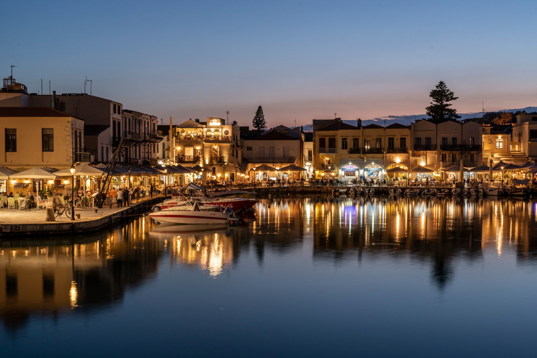Rethymno Venetian Harbor illuminated at night in Crete Greece with traditional boats