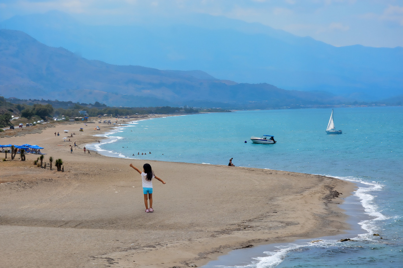 Φωτογραφία της μεγάλης αμμώδους παραλίας της Επισκοπής στο Ρέθυμνο με τη θάλασσα και τον καθαρό ορίζοντα.